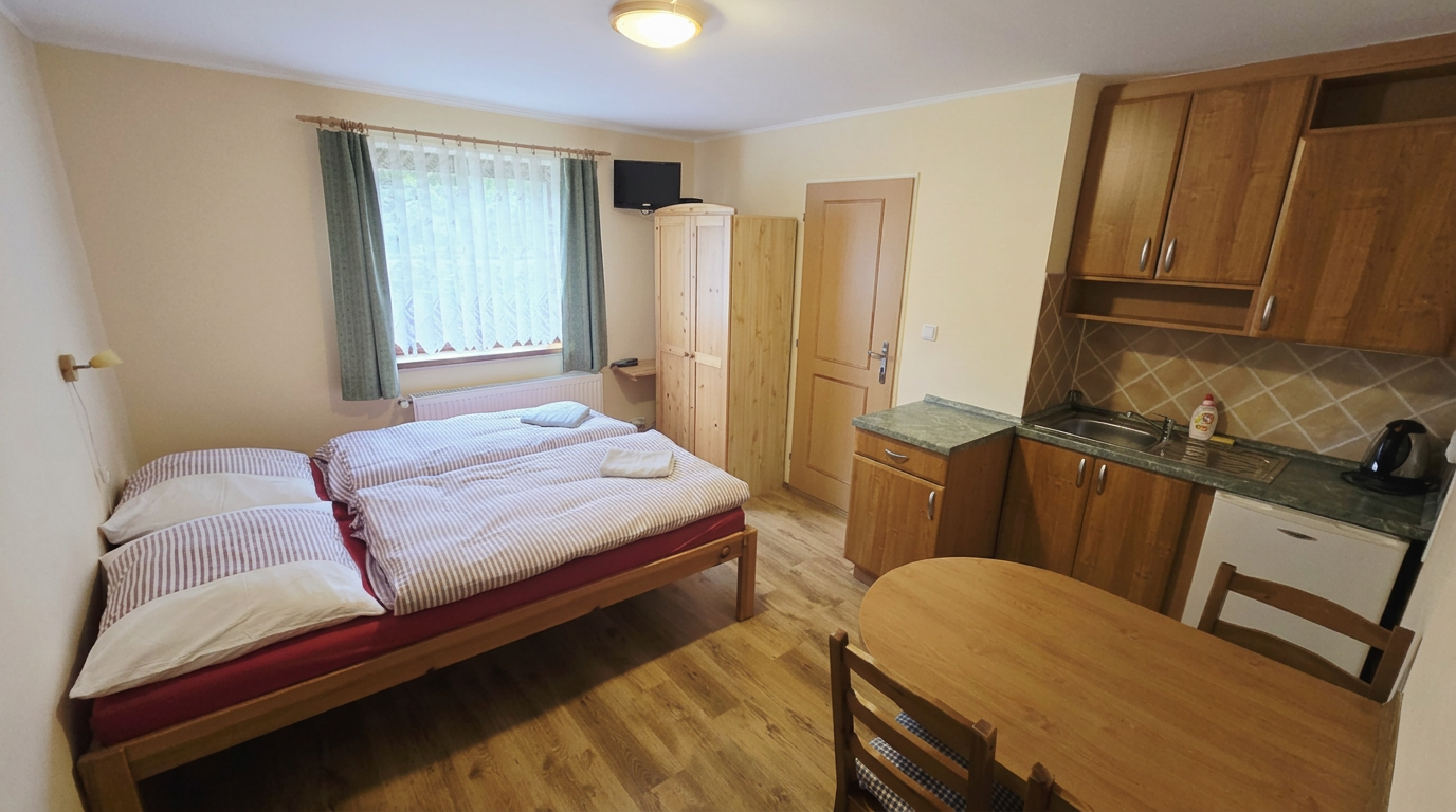 Ložnice s manželskou postelí a kuchyňským koutem – Apartmány Chaloupka, ubytování Jizerské hory